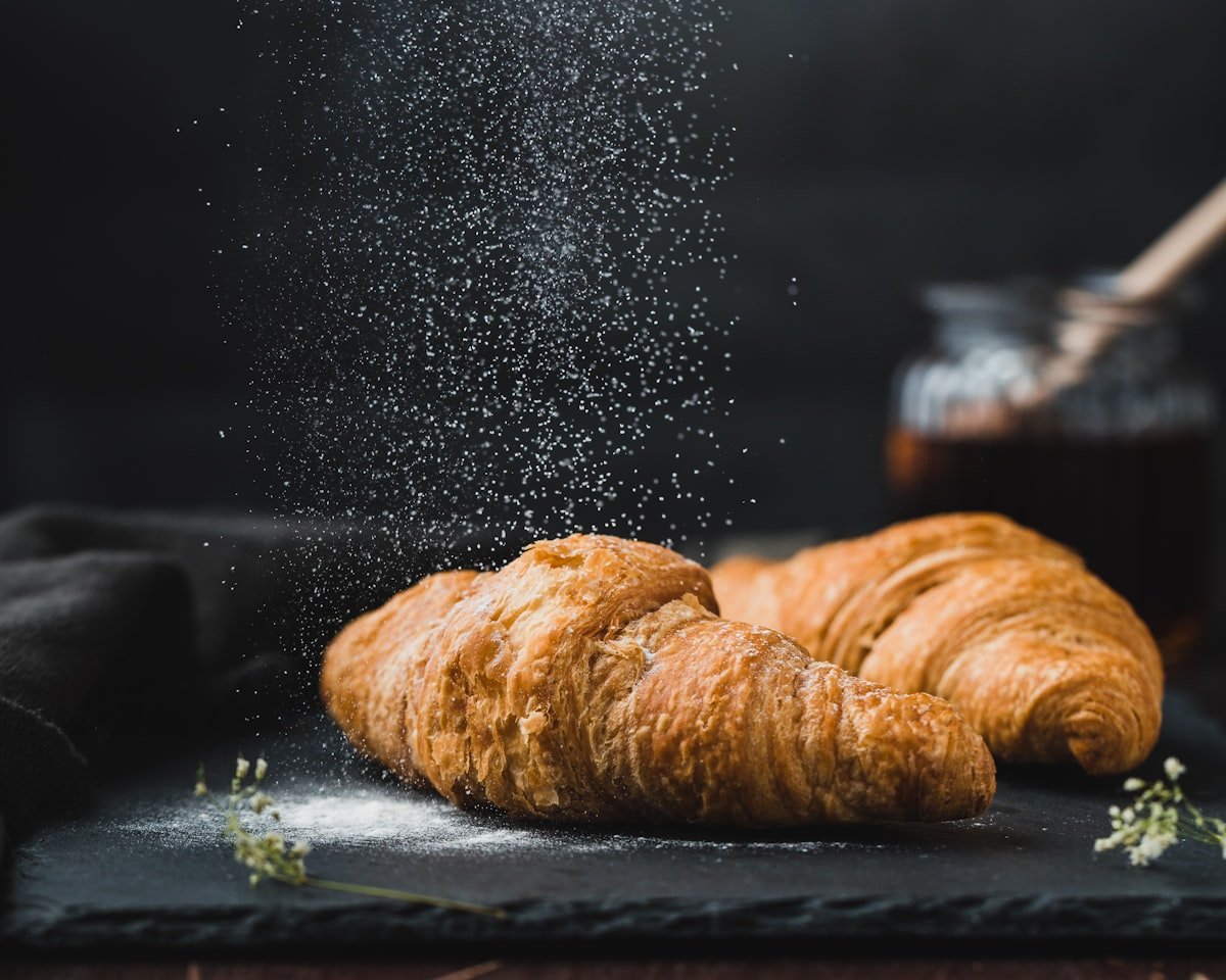 Stack of golden butter croissants on a marble counter